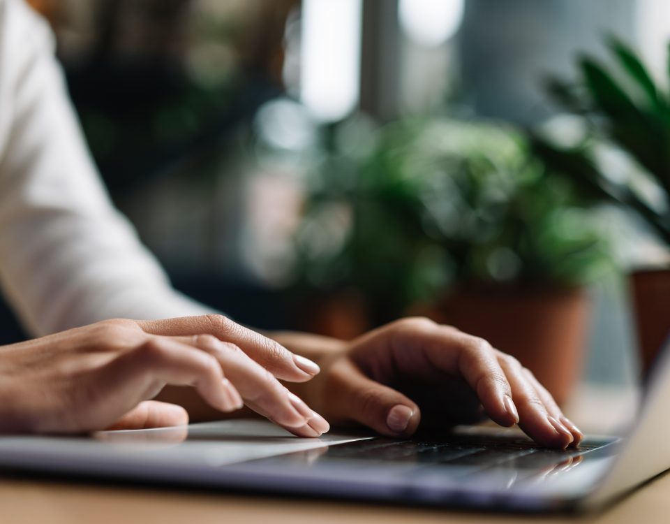 Hands typing on laptop