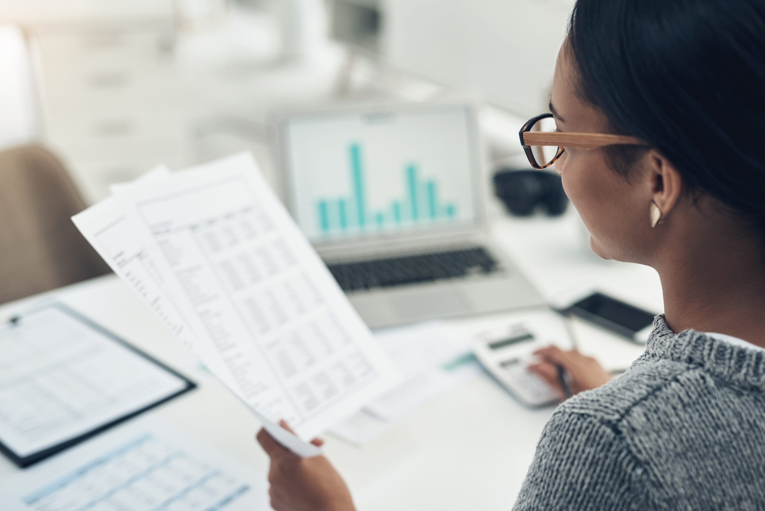 woman reading documents at desk